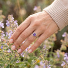 [KI] Silberring mit Amethyst an der Hand zwischen Blumen