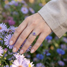 [KI] Silberring mit Amethyst an der Hand zwischen Blumen