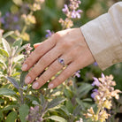 [KI] Silberring mit Amethyst an der Hand zwischen Blumen