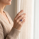 [KI] Frau trägt einen Amethystring aus Silber am Fenster