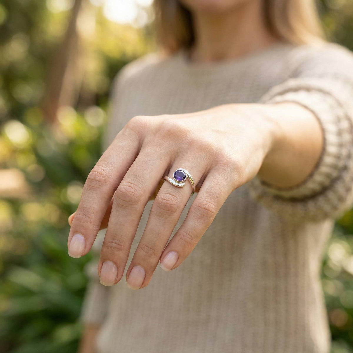 Amethystring aus Silber getragen an der Hand im Freien