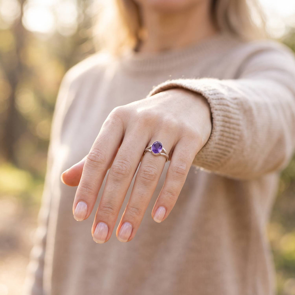 Amethystring aus Silber getragen an der Hand im Freien