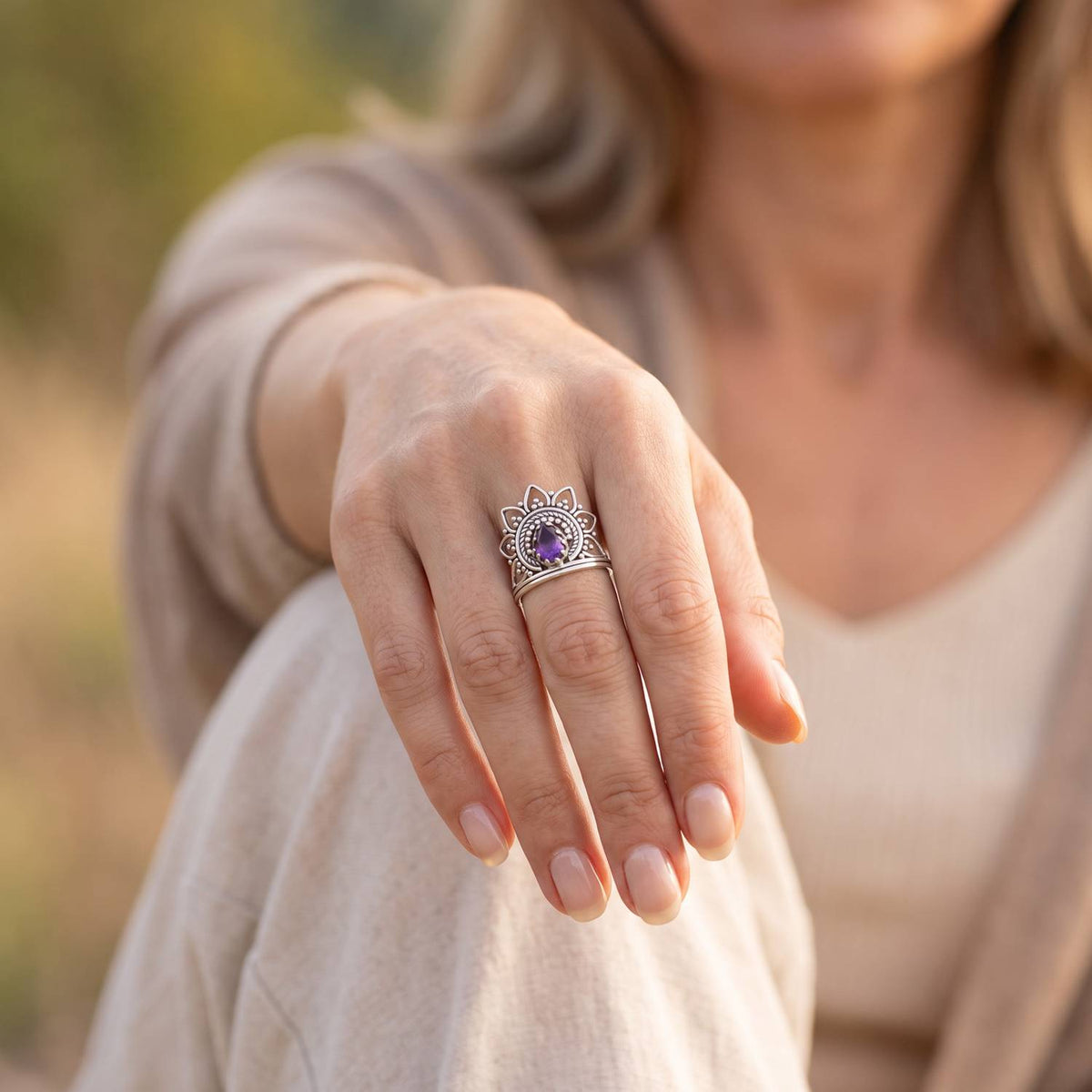 Amethystring aus Silber getragen an der Hand im Freien