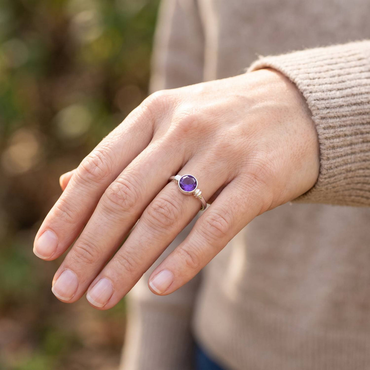 Amethystring aus Silber getragen an der Hand im Freien