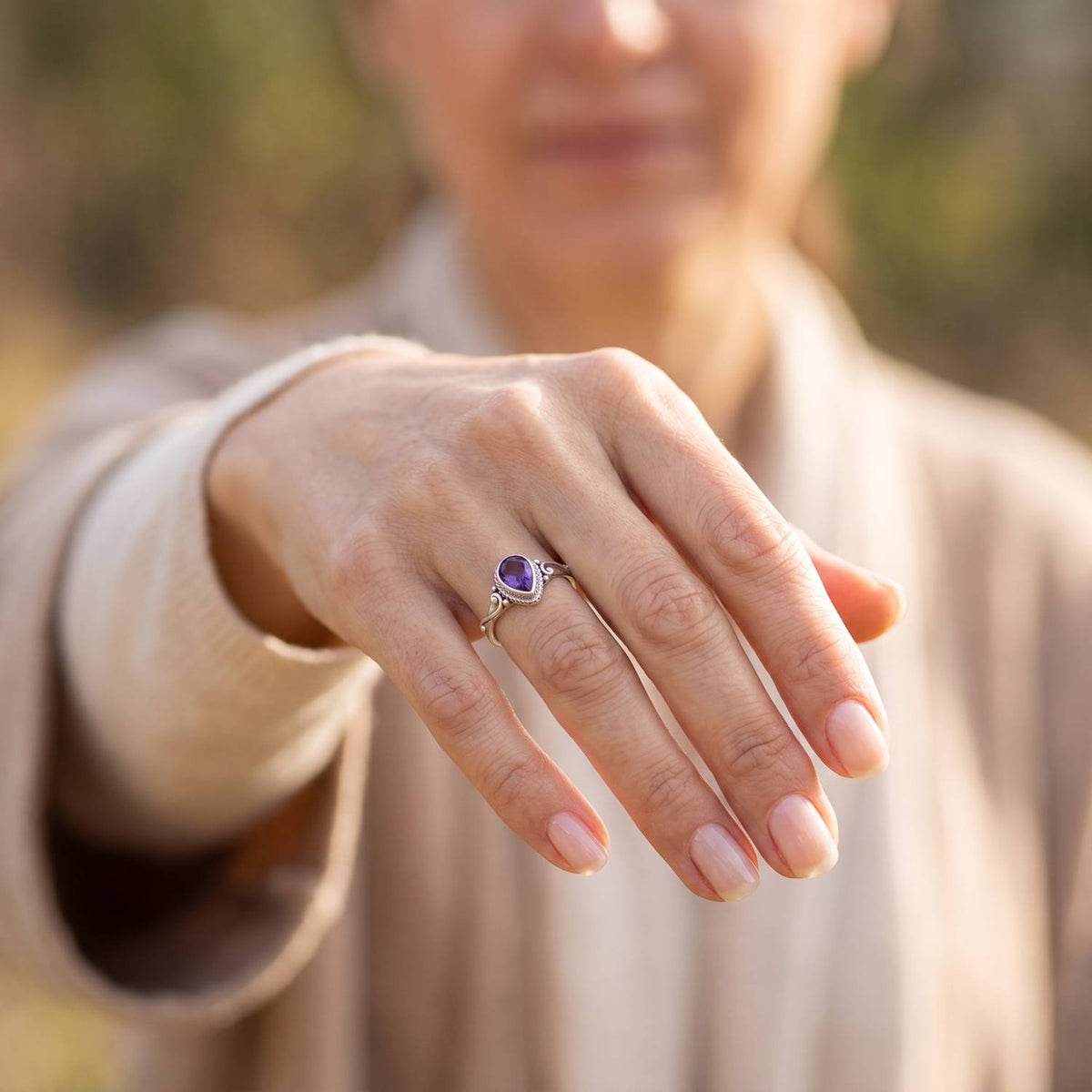 Amethystring aus Silber getragen an der Hand im Freien