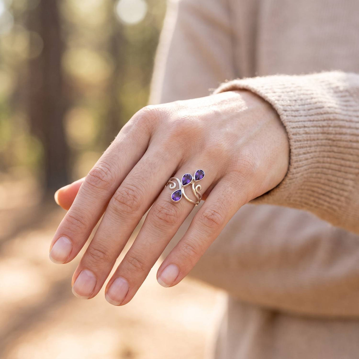 Amethystring aus Silber getragen an der Hand im Freien