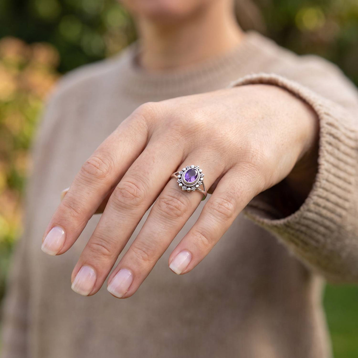 Amethystring aus Silber getragen an der Hand im Freien