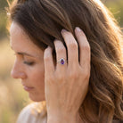 [KI] Frau trägt Silberring mit Amethyst an der Hand am Haar
