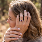[KI] Frau trägt Silberring mit Amethyst an der Hand am Haar
