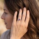 [KI] Frau trägt Silberring mit Amethyst an der Hand am Haar
