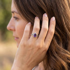 [KI] Frau trägt Silberring mit Amethyst an der Hand am Haar