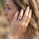 [KI] Frau trägt Silberring mit Amethyst an der Hand am Haar