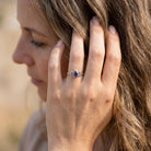 [KI] Frau trägt Silberring mit Amethyst an der Hand am Haar
