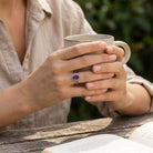 [KI] Amethystring aus Silber getragen beim Lesen mit einer Tasse