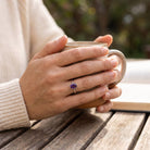 [KI] Amethystring aus Silber getragen beim Lesen mit einer Tasse