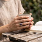 [KI] Amethystring aus Silber getragen beim Lesen mit einer Tasse