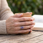 [KI] Amethystring aus Silber getragen beim Lesen mit einer Tasse