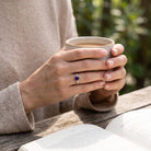 [KI] Amethystring aus Silber getragen beim Lesen mit einer Tasse