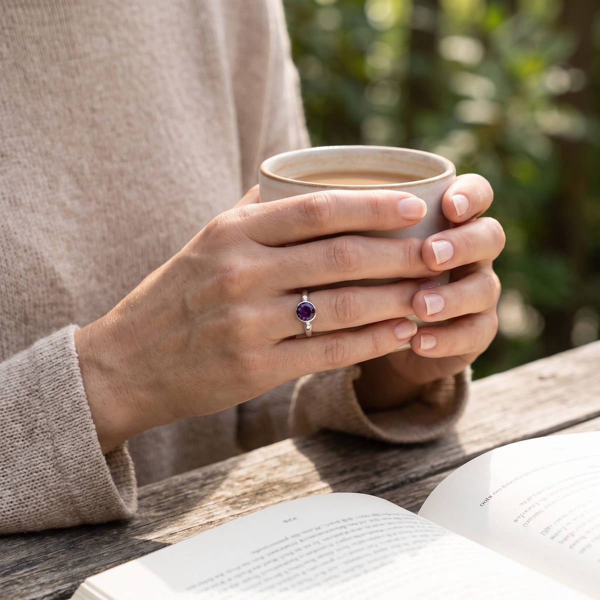 Amethystring aus Silber getragen beim Lesen mit einer Tasse