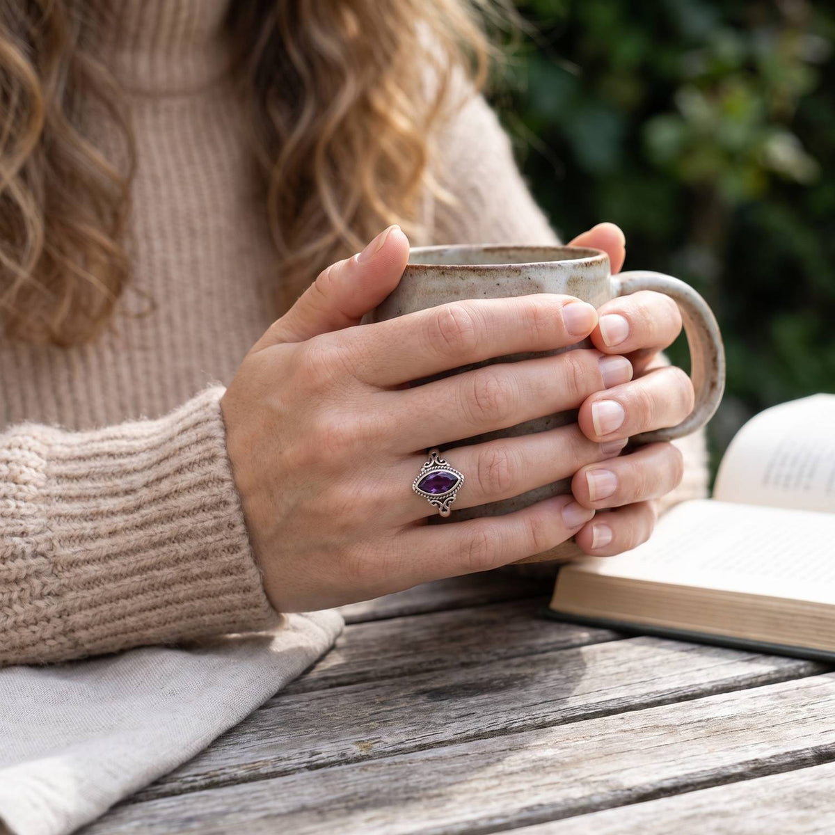 Amethystring aus Silber getragen beim Lesen mit einer Tasse