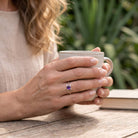[KI] Amethystring aus Silber getragen beim Lesen mit einer Tasse