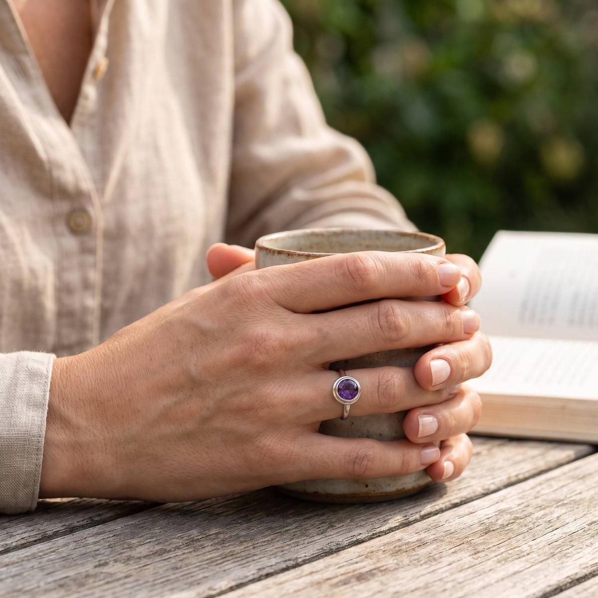 Amethystring aus Silber getragen beim Lesen mit einer Tasse