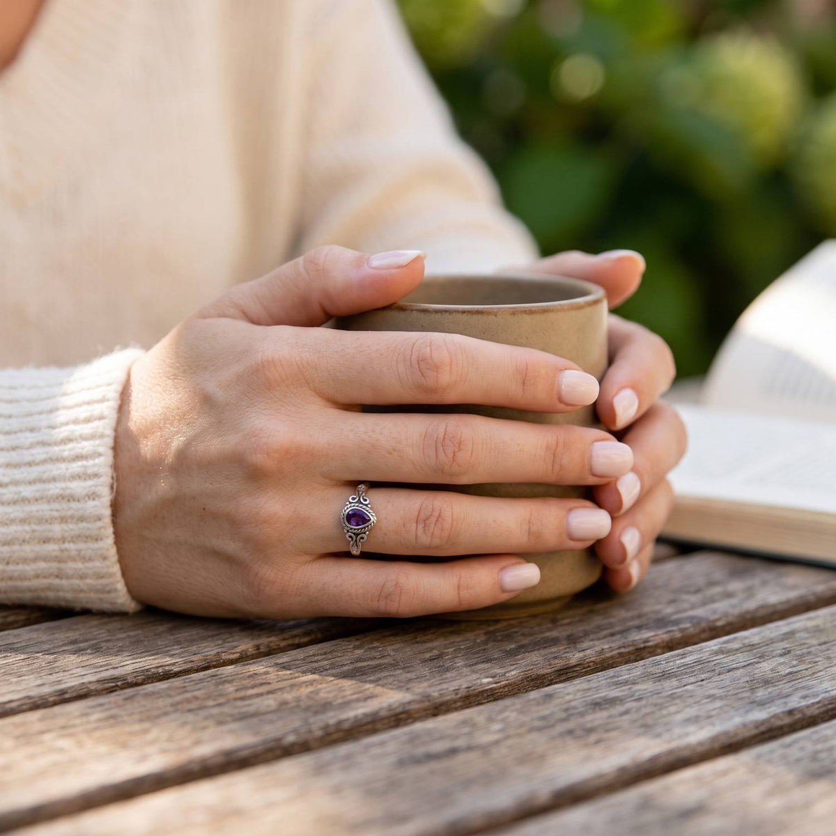 Amethystring aus Silber getragen beim Lesen mit einer Tasse
