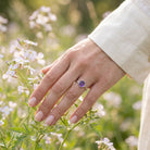 [KI] Silberring mit Amethyst an der Hand zwischen Blumen