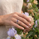 [KI] Silberring mit Amethyst an der Hand zwischen Blumen