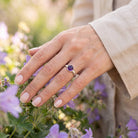 [KI] Silberring mit Amethyst an der Hand zwischen Blumen