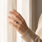 [KI] Frau trägt einen Amethystring aus Silber am Fenster
