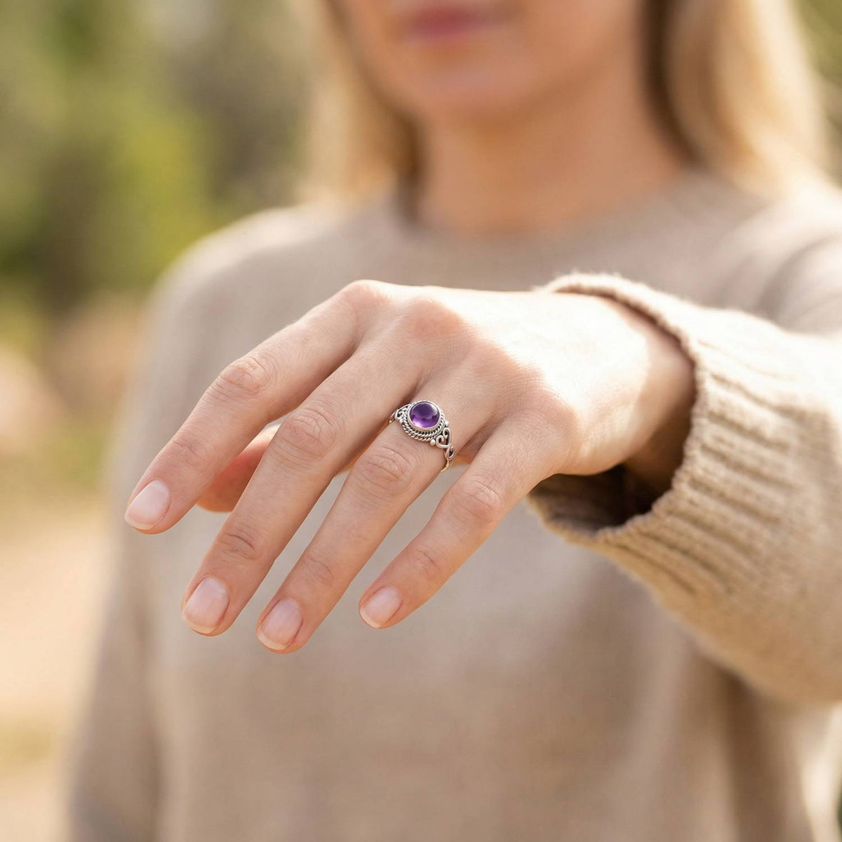Amethystring aus Silber getragen an der Hand im Freien