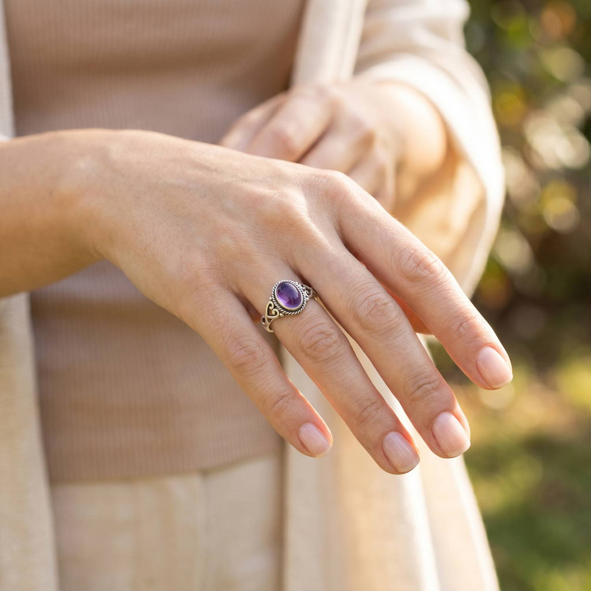 Amethystring aus Silber getragen an der Hand im Freien