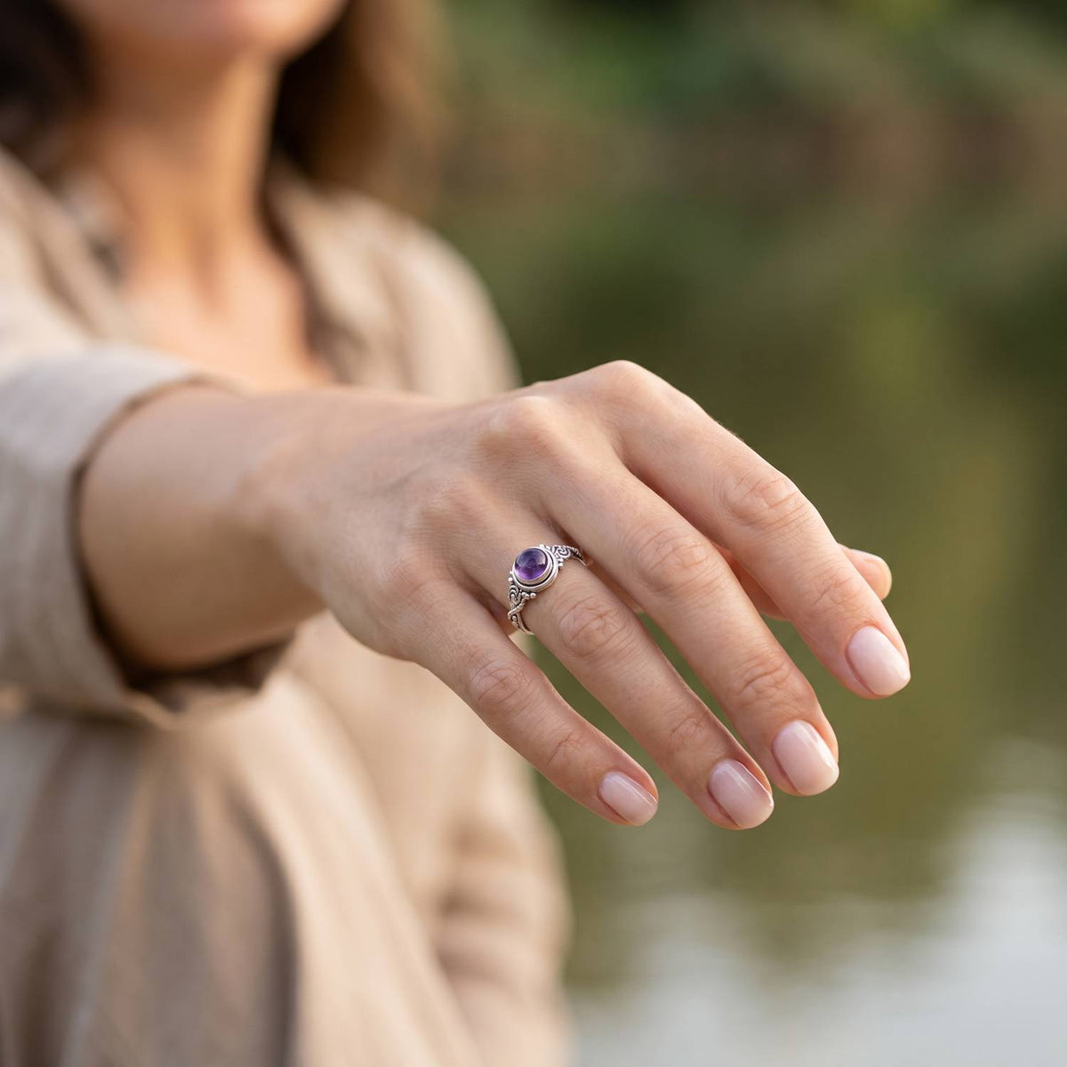 Amethystring aus Silber getragen an der Hand im Freien