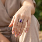 [KI] Amethystring aus Silber getragen an der Hand im Freien