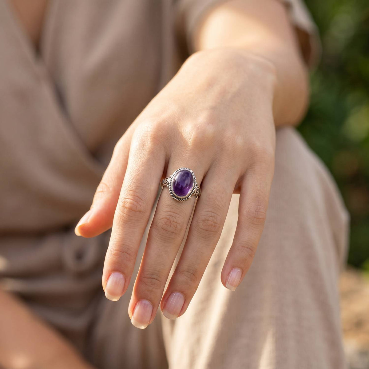 Amethystring aus Silber getragen an der Hand im Freien