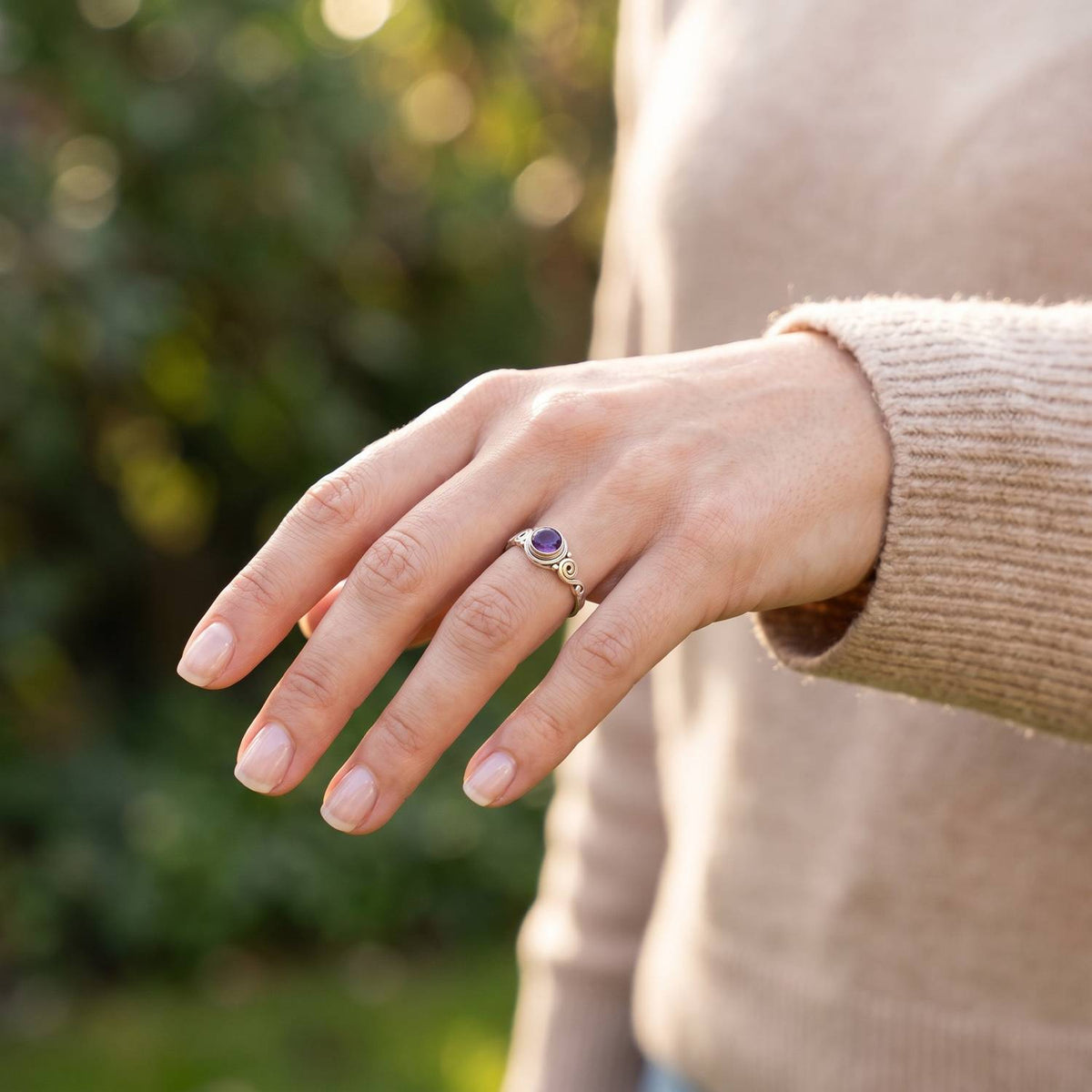Amethystring aus Silber getragen an der Hand im Freien