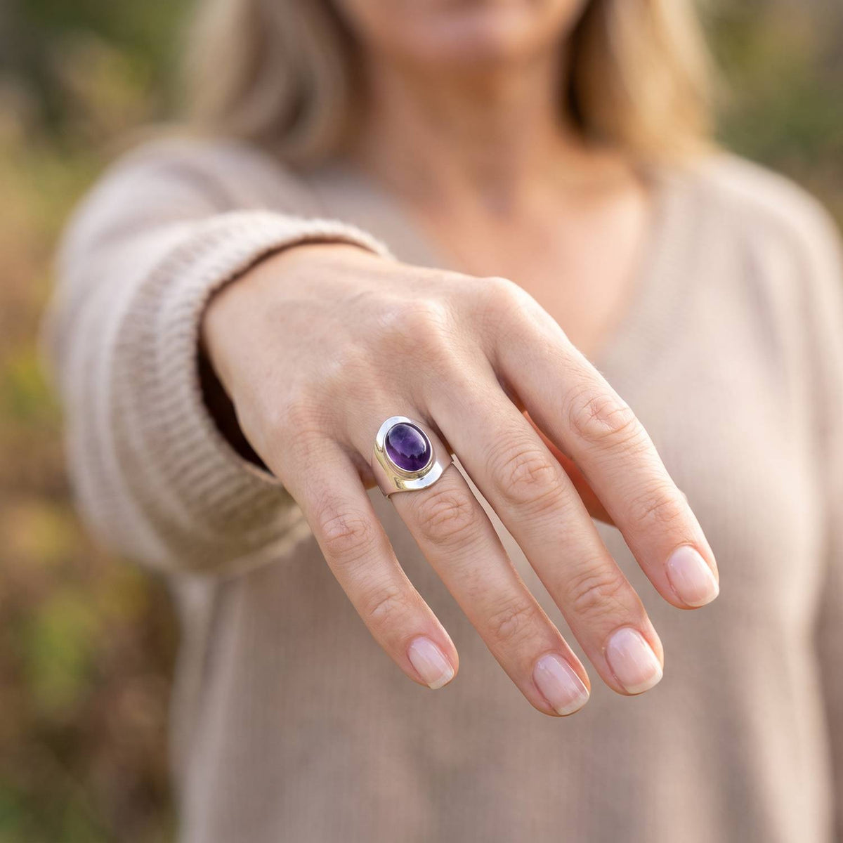 Amethystring aus Silber getragen an der Hand im Freien