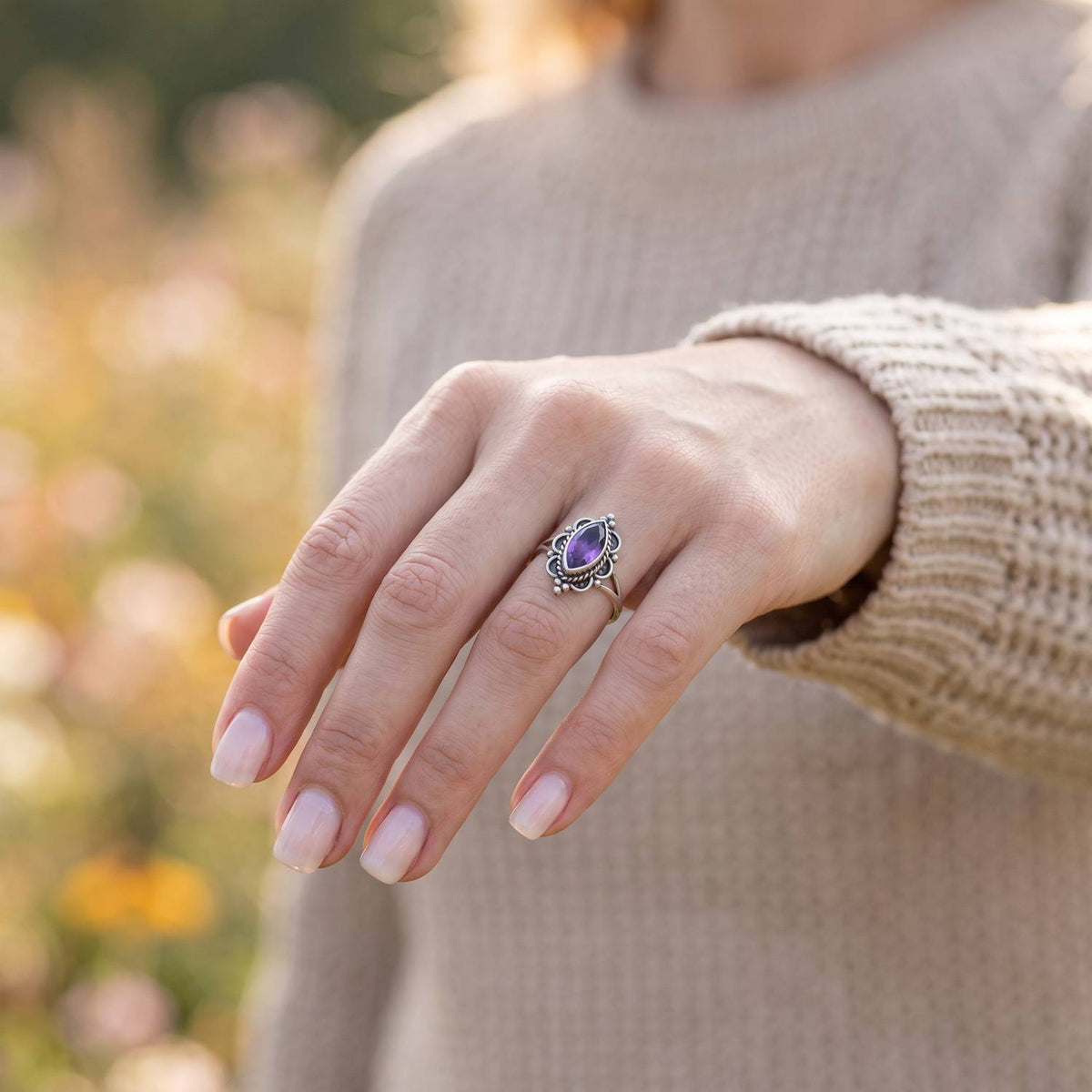 Amethystring aus Silber getragen an der Hand im Freien