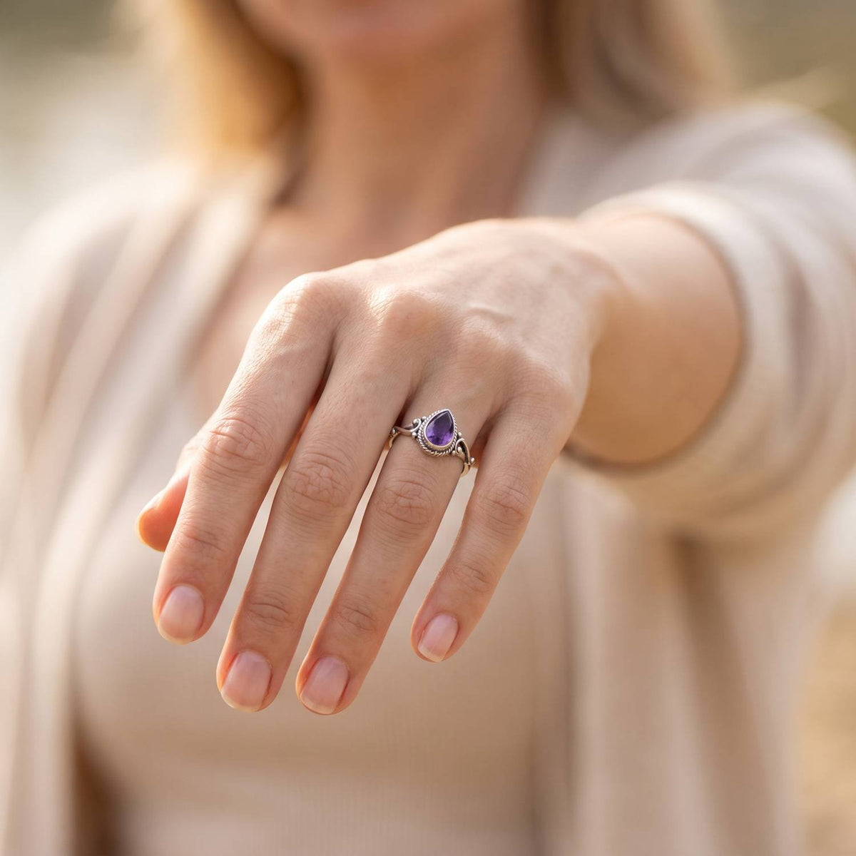 Amethystring aus Silber getragen an der Hand im Freien