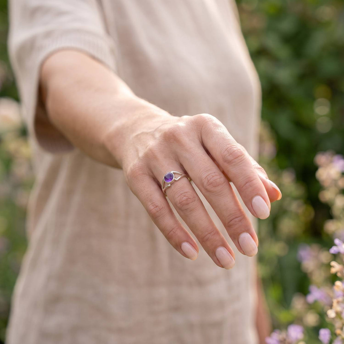Amethystring aus Silber getragen an der Hand im Freien