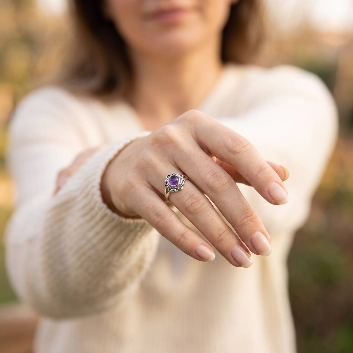 Amethystring aus Silber getragen an der Hand im Freien