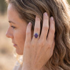 [KI] Frau trägt Silberring mit Amethyst an der Hand am Haar