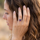 [KI] Frau trägt Silberring mit Amethyst an der Hand am Haar