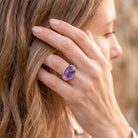 [KI] Frau trägt Silberring mit Amethyst an der Hand am Haar
