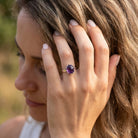 [KI] Frau trägt Silberring mit Amethyst an der Hand am Haar