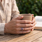 [KI] Amethystring aus Silber getragen beim Lesen mit einer Tasse