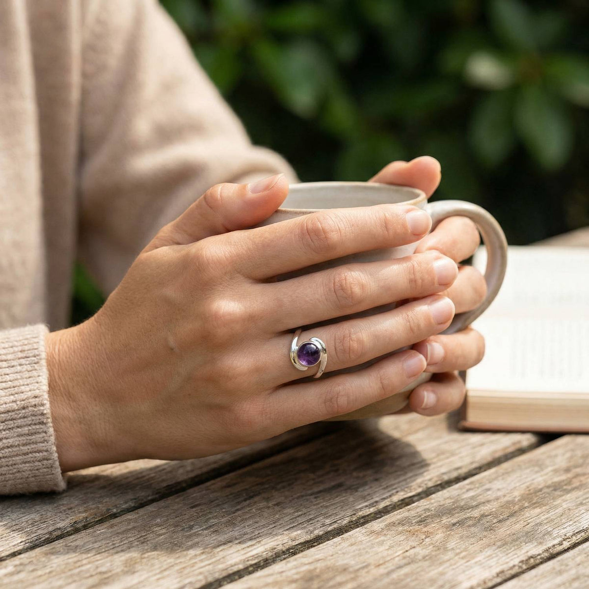 Amethystring aus Silber getragen beim Lesen mit einer Tasse