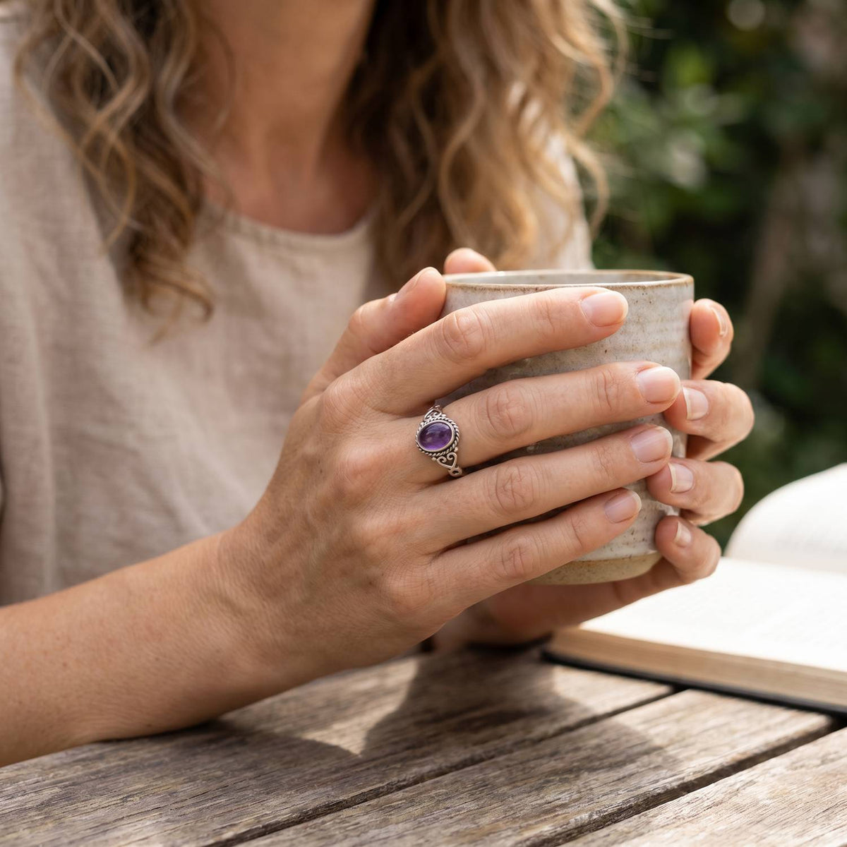 Amethystring aus Silber getragen beim Lesen mit einer Tasse