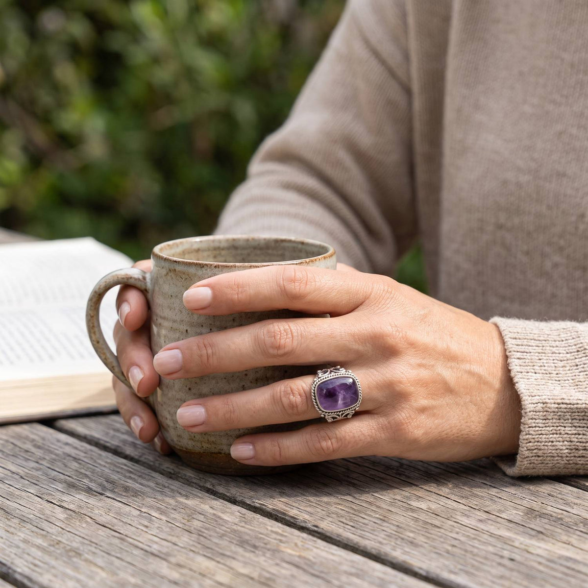 Amethystring aus Silber getragen beim Lesen mit einer Tasse